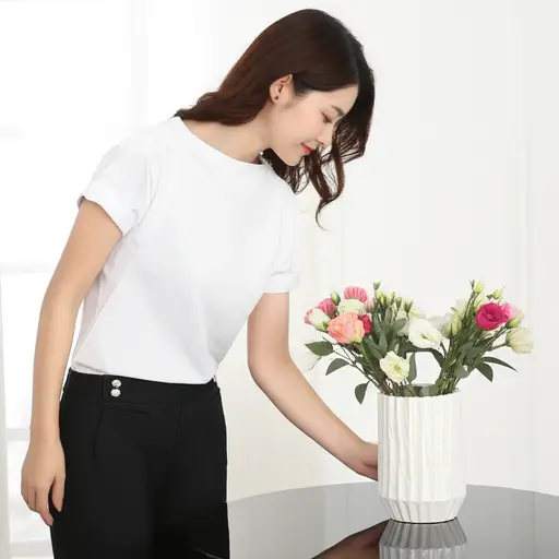 她不小心轻推了一下花瓶，差点把它碰倒。