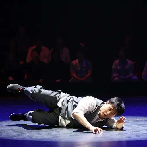 他在表演中在舞台上绊倒，出了丑。
