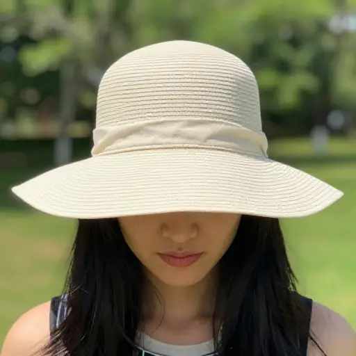 她戴了一顶软塌的帽子来遮挡明亮的阳光。