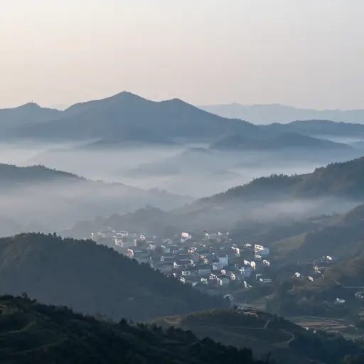 从山顶上，我突然看到了一个笼罩在雾中的遥远村庄。