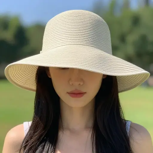 她戴着一顶软塌塌的帽子来遮挡阳光。