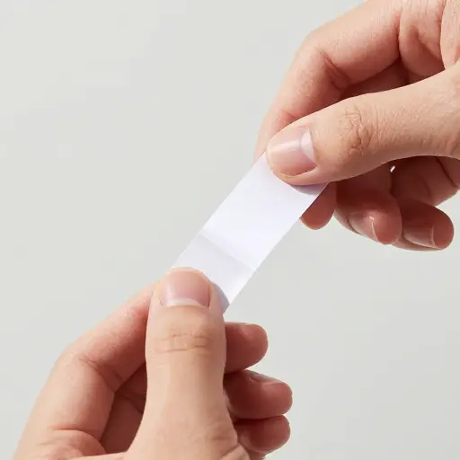剥下背条，然后用力按压标签。