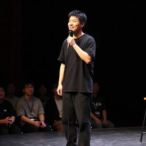 突然，他从舞台上引起了我的注意，并露出了会心的微笑。
