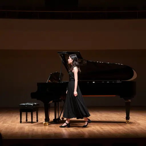 她带着忐忑不安的心情踏上空荡荡的舞台，第一场独奏即将开始。
